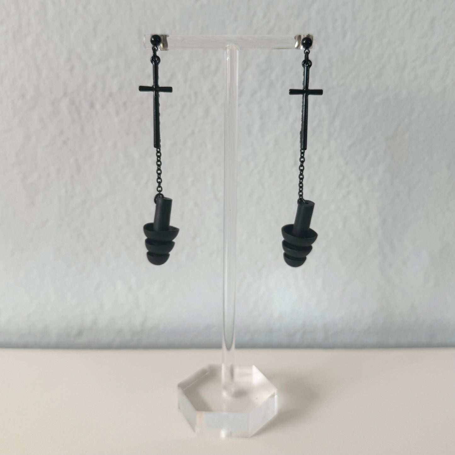 Black Sinister Earplug Earrings with black crosses and black silicone ear plugs attached. Sensory friendly jewelry for raves and concerts.