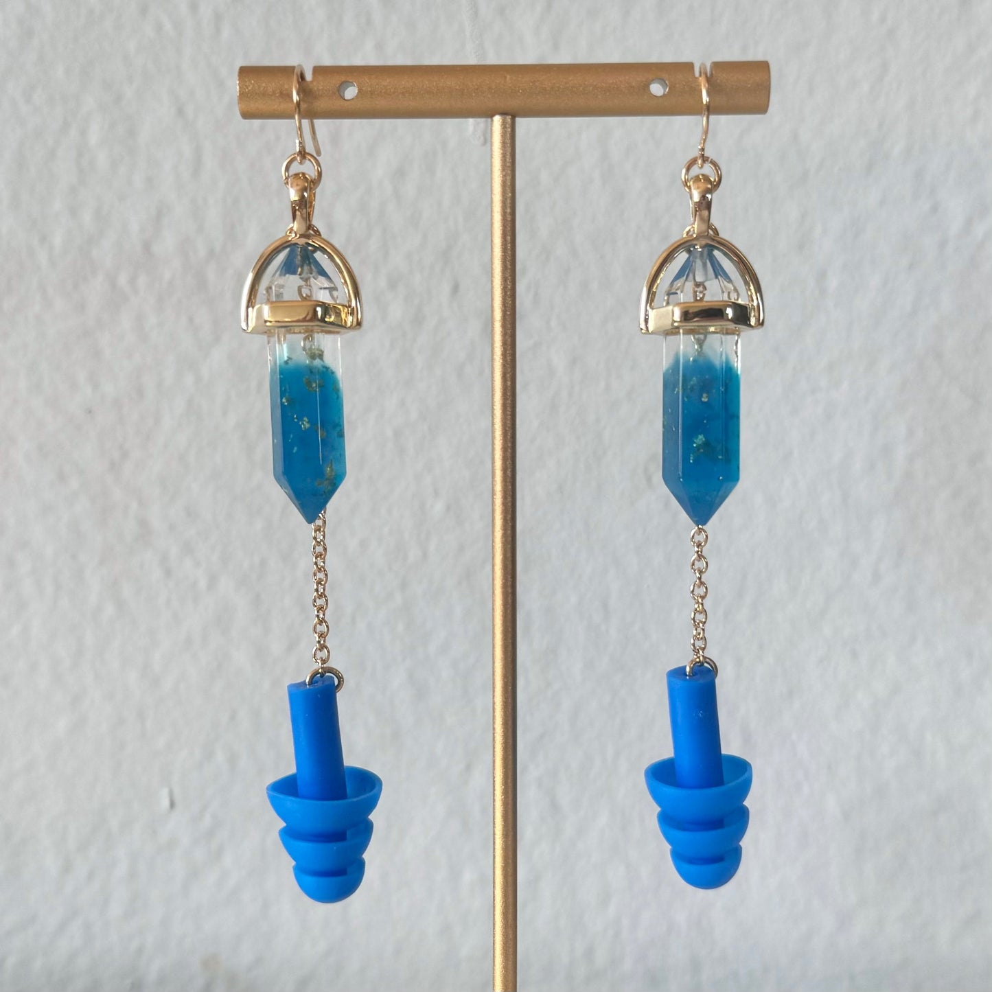Earplug Earrings with deep blue crystals and matching blue ear plugs with gold chain and setting. Ear plug earring jewelry offers stylish and convenient hearing protection and noise reduction. The perfect gift for ravers and edm lovers