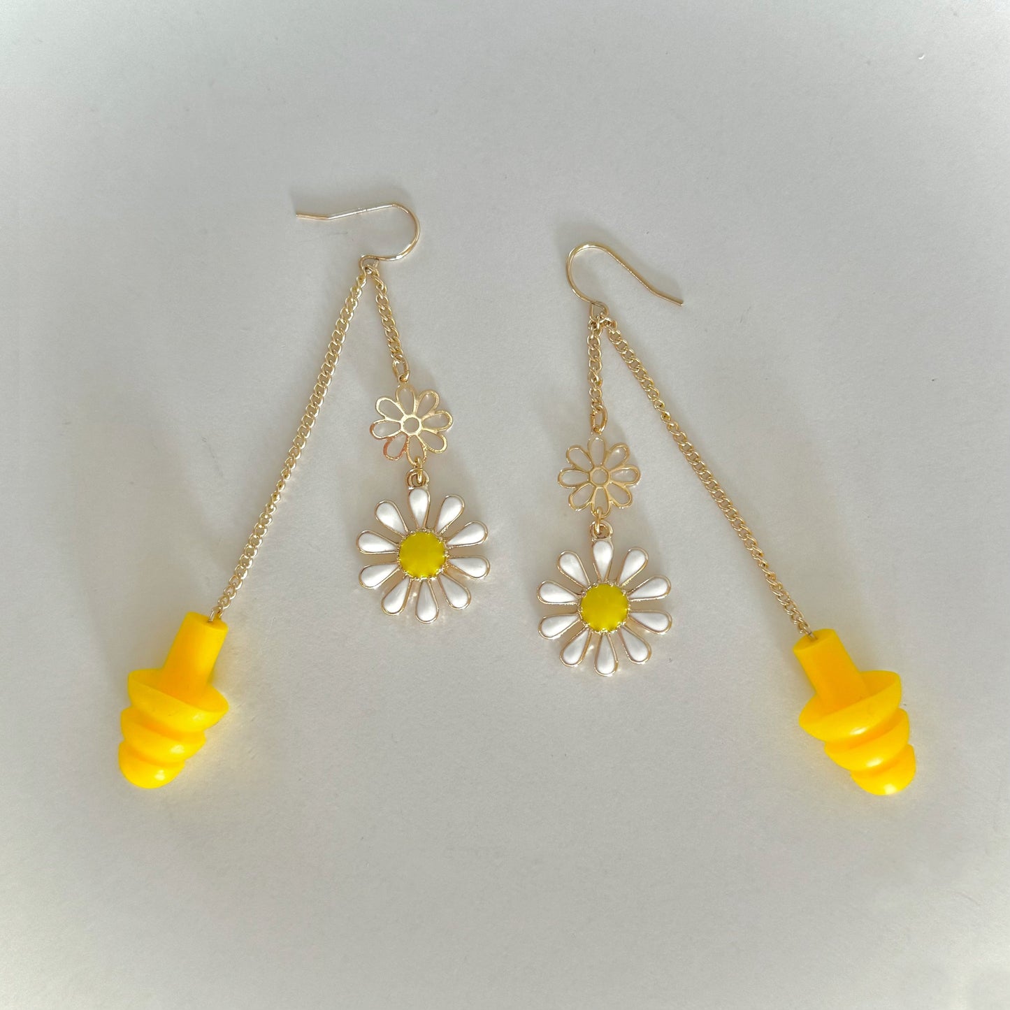 Yellow and white daisy earplug earrings with yellow ear plugs attached.