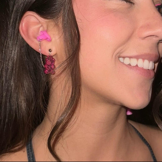 Cute neon pink gummy bear earplug earrings with silver accents and matching earplugs. Perfect noise-reduction accessory for EDM lovers and festival goers.