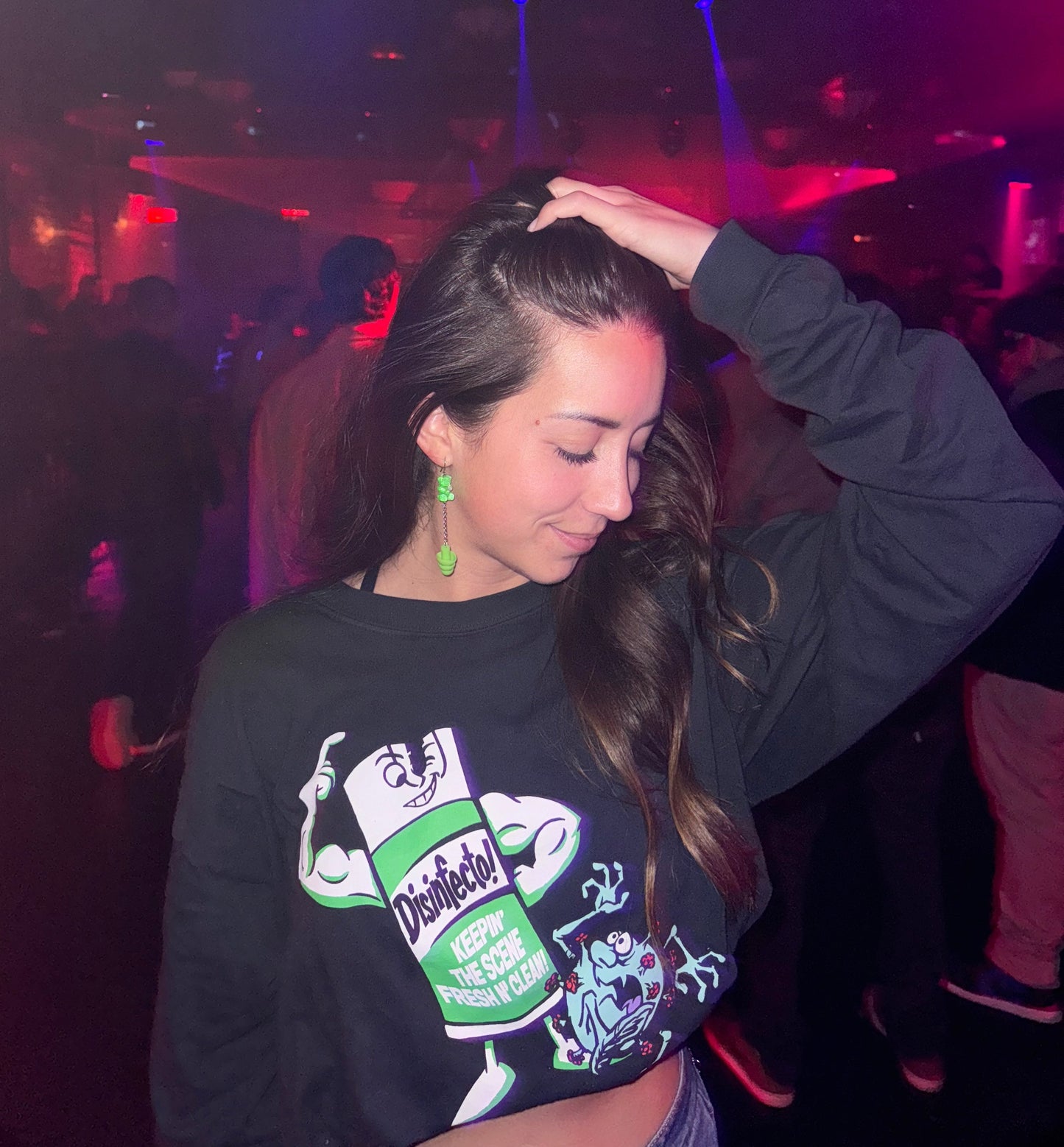 Girl wearing Green gummy bear earplug earrings with matching green earplugs, silver chains, and setting, combining style and hearing protection. Ideal for ravers and EDM fans.