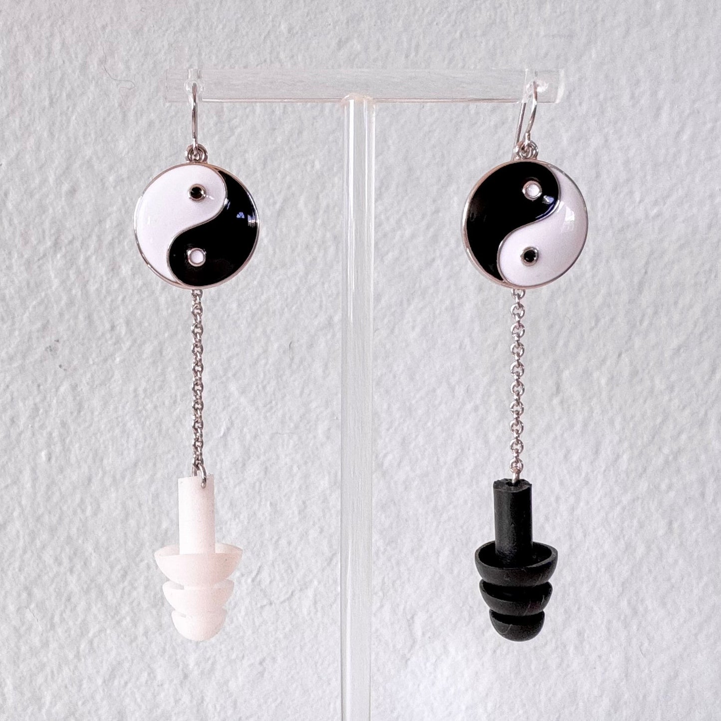 Yin and Yang earplug earrings with black and white silicone ear plugs attached. Sensory friendly jewelry for raves and concerts.