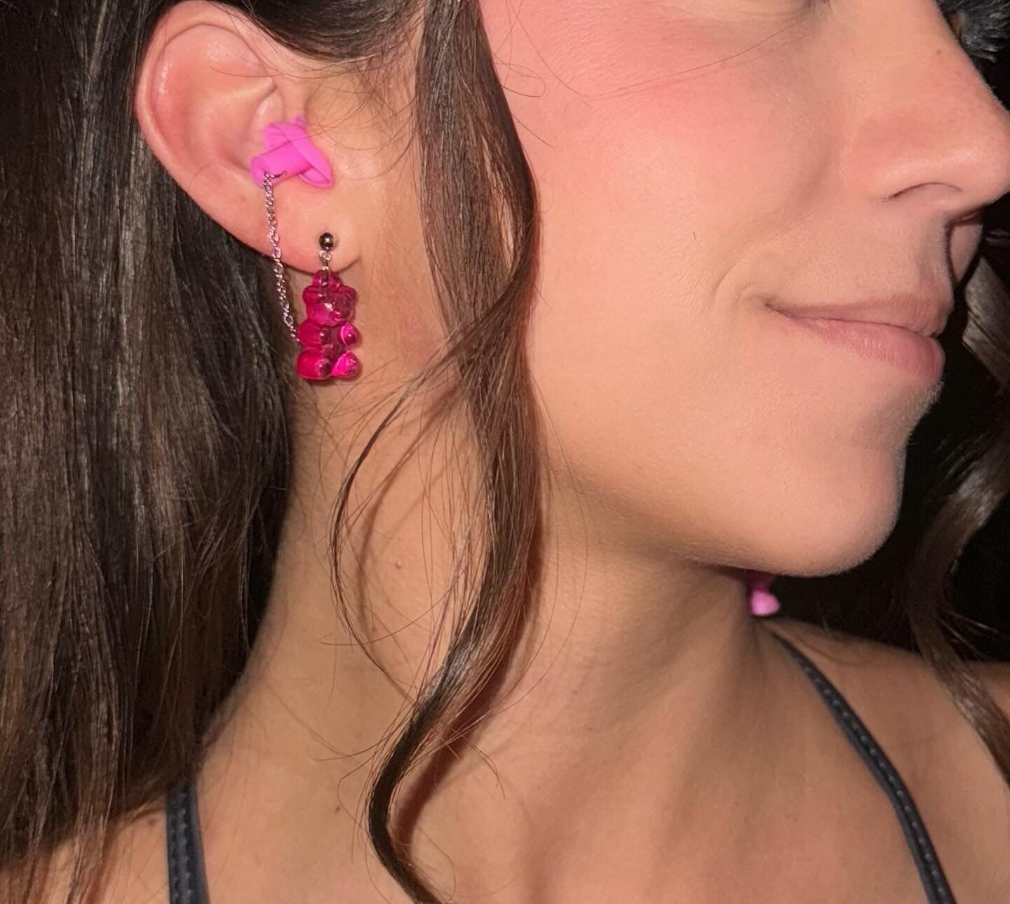 Pink gummy bear ear plug earrings featuring silver chains and earplugs. A stylish and fun hearing protection gift for ravers and techno enthusiasts.