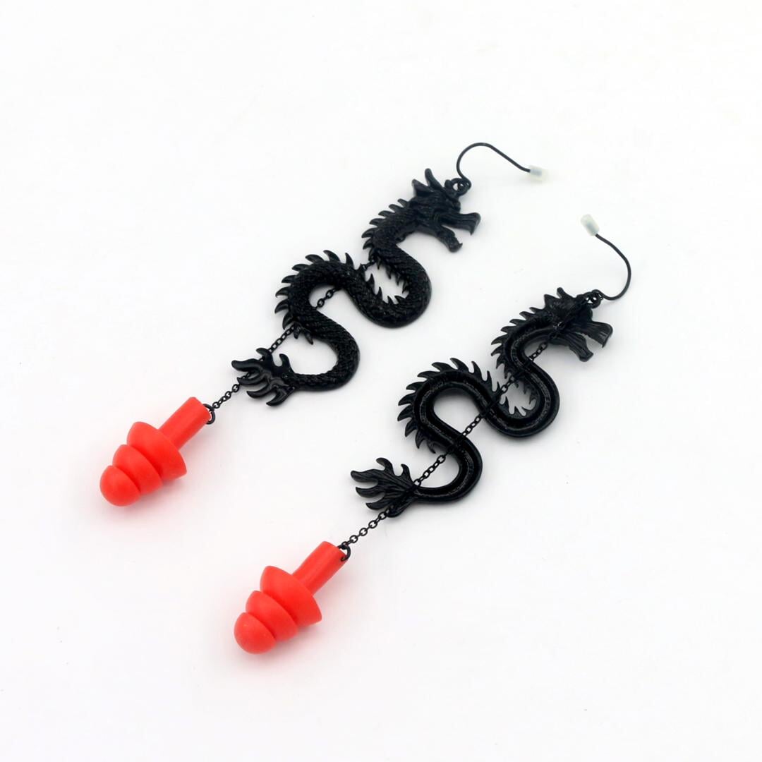 Black Dragon ear plug earrings with red silicone ear plugs attached.