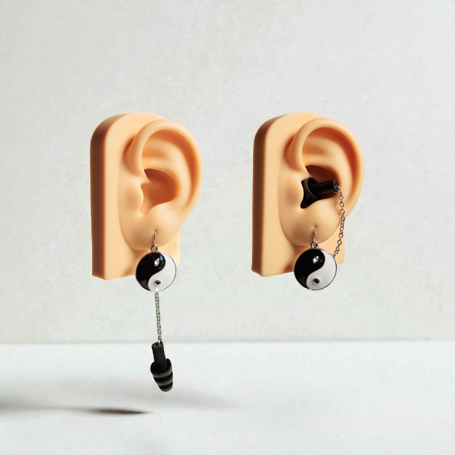 Yin and Yang Black and white earrings with earplugs in ear