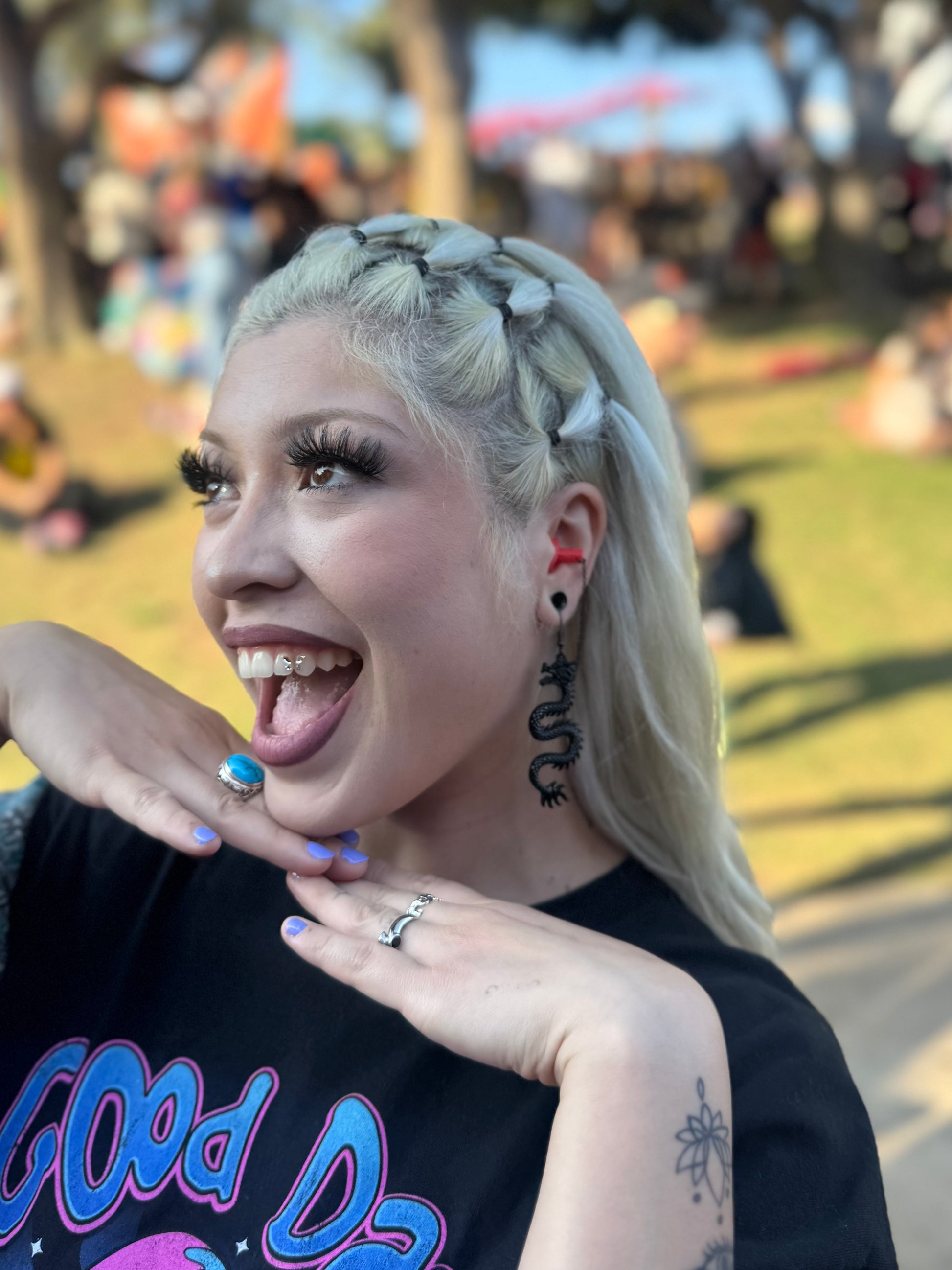 Woman wearing sensory friendly earplug earrings with black dragons and red silicone ear plugs. Zoomed in view. 