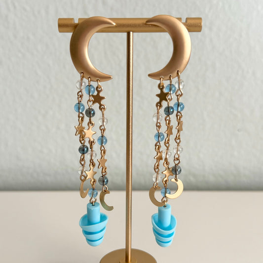Gold moon Starry night chain drops on earring stand. Earplug earrings with blue beads, perfect gift for ravers seeking style and hearing protection. Sensory-friendly earrings with attached earplugs.